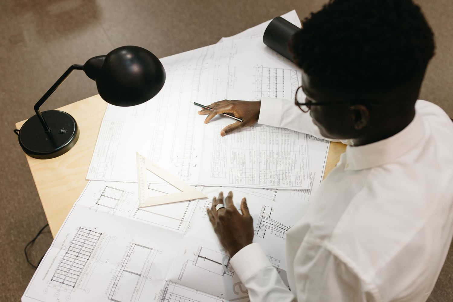 A surveyor working through technical drawings at a desk